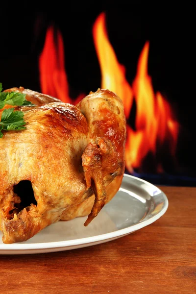 Pollo intero arrosto su un piatto bianco su sfondo di legno primo piano — Foto Stock