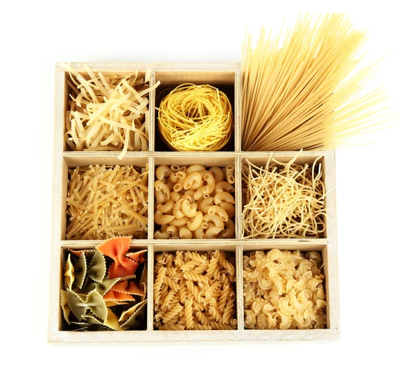 Nine types of pasta in wooden box sections isolated on white — Stock Photo, Image