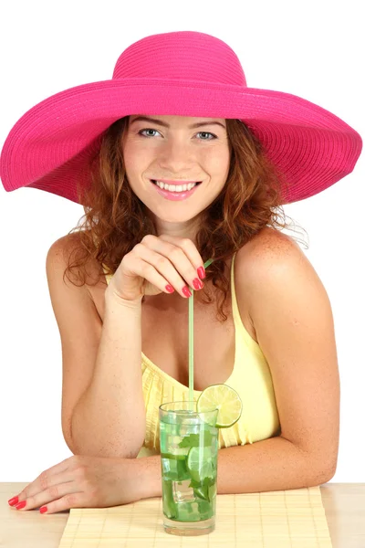 Sorridente bella ragazza seduta a tavola con cappello da spiaggia e cocktail iso — Foto Stock