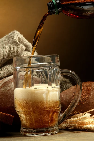 Kvas gegoten in een mok en rogge brood met oren, op houten tafel op brown — Stockfoto