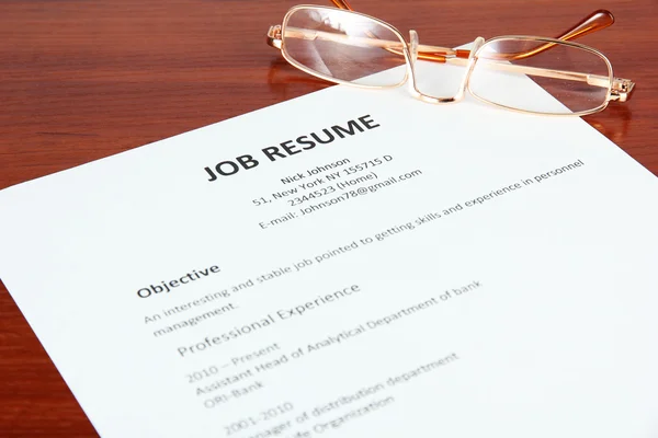 Closeup of resume with glasses on wooden table — Stock Photo, Image