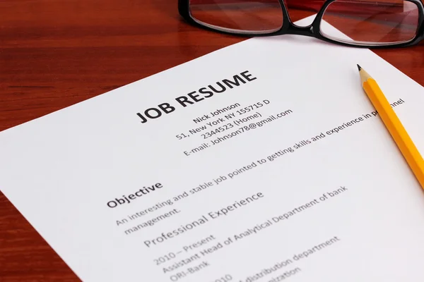 Closeup of resume with pencil and glasses on wooden table — Stock Photo, Image