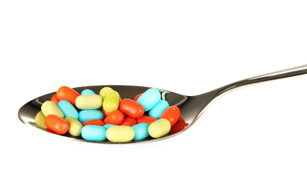 Colorful pills on spoon on white background close-up — Stock Photo, Image