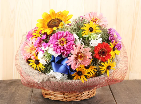 Bellissimo bouquet di fiori luminosi in saccheggio su sfondo di legno — Foto Stock