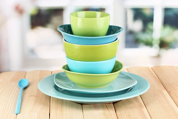 Blue and green tableware on wooden table on window background — Stock Photo, Image