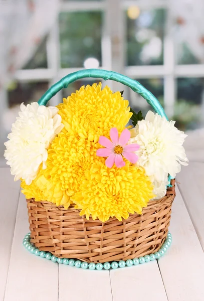 Schöne Chrysantheme im Korb auf Holztisch auf Fensterhintergrund — Stockfoto