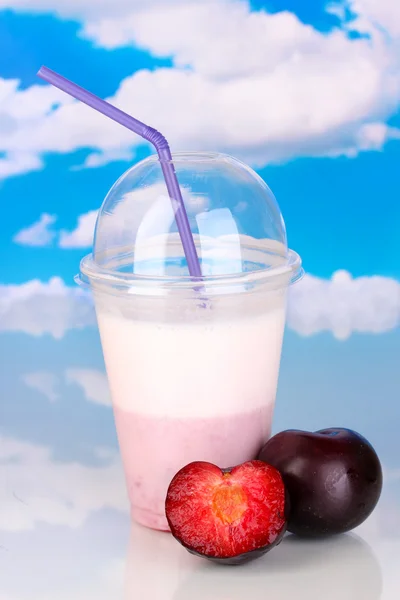 Смачне молоко тремтить з фруктами на столі на фоні неба — стокове фото