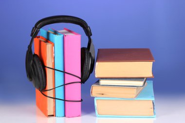 mavi zemin üzerine kitaplar üzerinde kulaklık