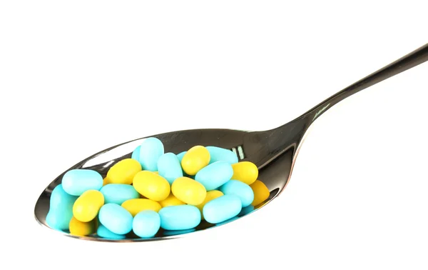 Píldoras de colores en cuchara sobre fondo blanco de cerca —  Fotos de Stock