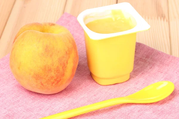 Yogurt with peach on wooden table — Stock Photo, Image