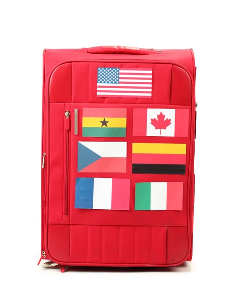Červený kufr s mnoha samolepky s vlajkami různých zemí, izolované — Stock fotografie
