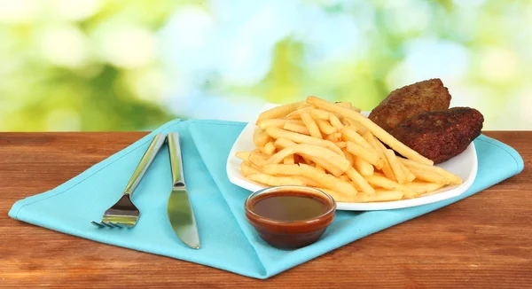 Aardappelen friet met hamburgers op de plaat op groene achtergrond close-up — Stockfoto