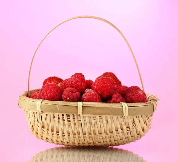 Maliny v košíku na růžovém pozadí — Stock fotografie