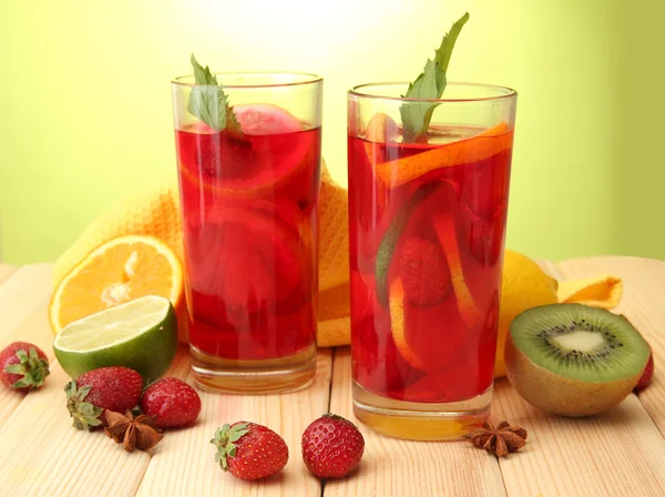 Sangria i glas med frukter, på träbord, på grön bakgrund — Stockfoto