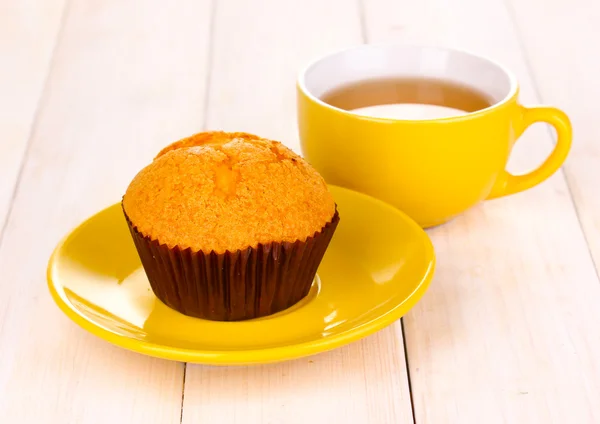 Frischer Muffin mit Tee auf Holzgrund — Stockfoto