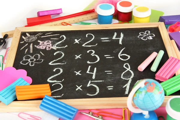 Small school desk with various school supplies close-up isolated on white — Stock Photo, Image