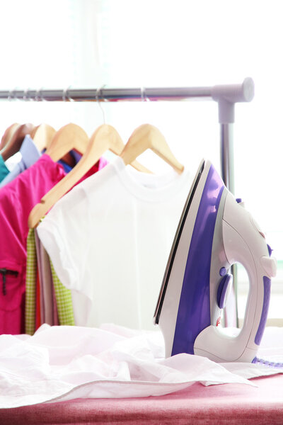 Electric iron and shirt, on cloth background