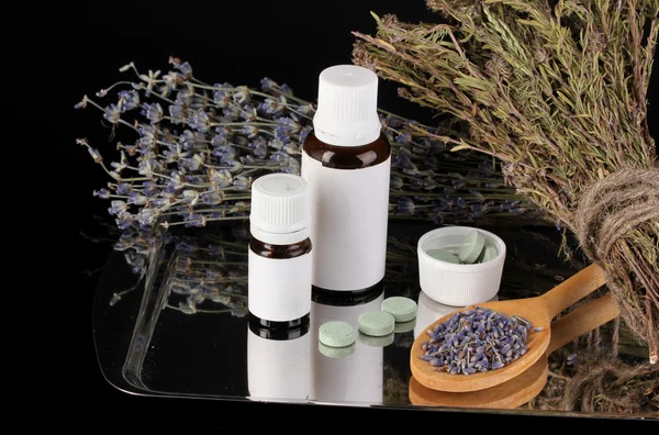 Bottles of medicines and herbs on black background. concept of homeopathy — Stock Photo, Image
