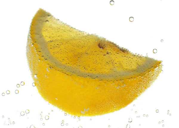 Fatia de limão na água com bolhas, isolado em branco — Fotografia de Stock