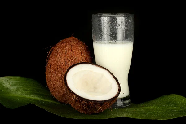 Vaso de leche de coco y coco sobre fondo negro de cerca —  Fotos de Stock