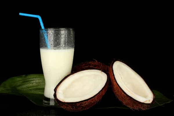 Glas kokosmjölk och kokosnötter isolerade på svart — Stockfoto