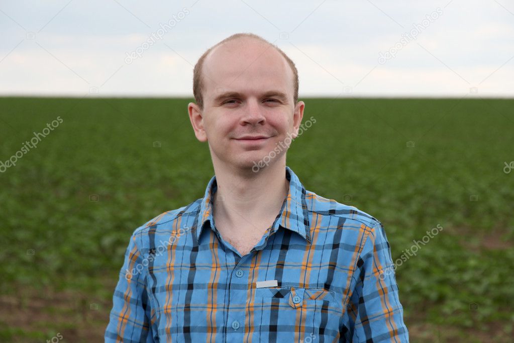 Young farmer standing near field