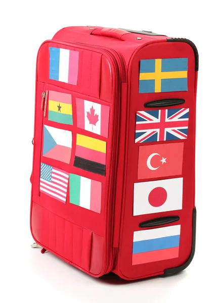 Red suitcase with many stickers with flags of different countries isolated — Stock Photo, Image