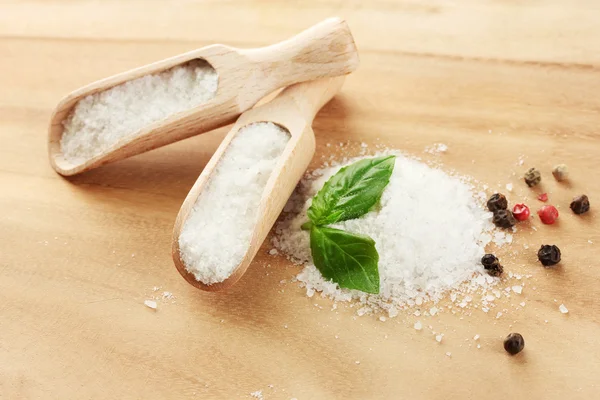 Salz mit frischem Basilikum und Pfeffer auf Holztisch — Stockfoto