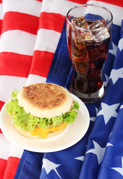 Leckeres Sandwich und Glas mit Cola, auf amerikanischer Flagge — Stockfoto