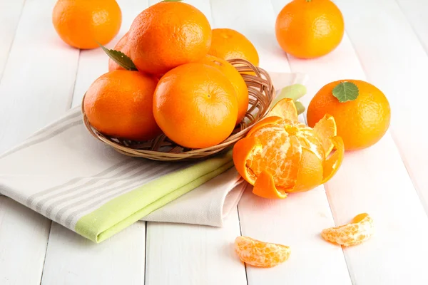 Tangerines με αφήνει σε ένα όμορφο καλάθι, στο λευκό ξύλινο τραπέζι — Φωτογραφία Αρχείου