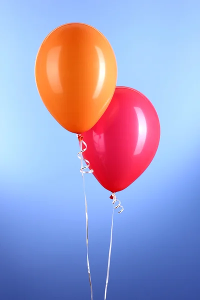 Två färgglada ballonger på blå bakgrund — Stockfoto