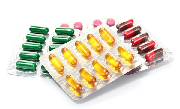 Capsules and pills packed in blisters, isolated on white — Stock Photo, Image