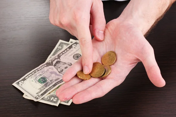 Підрахунок грошей в руці на дерев'яному фоні столу — стокове фото
