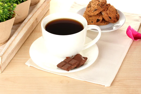 Taza de café, galletas, chocolate y flores en la mesa en la cafetería — Foto de Stock