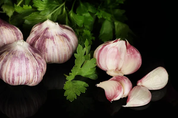 Jonge knoflook gepeld en UI met groen op zwarte achtergrond close-up — Stockfoto