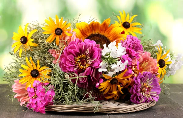 Beautiful bouquet of bright flowers on wooden table on nature background — Stock Photo, Image