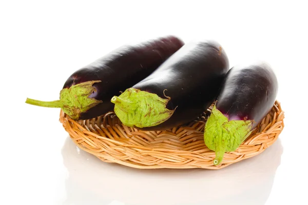 Verse aubergines op rieten mat geïsoleerd op wit — Stockfoto