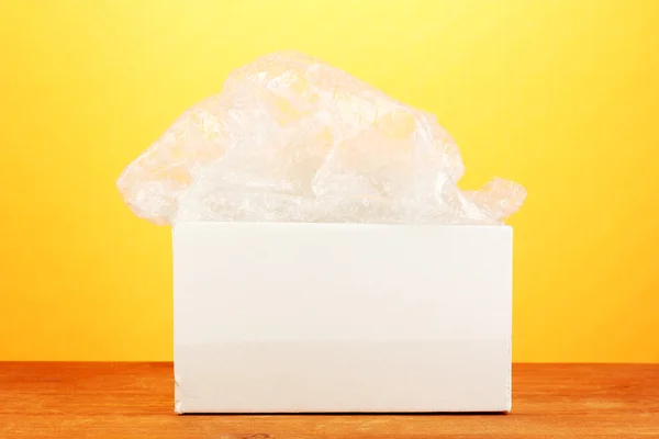 Opened parcel on yellow background close-up — Stock Photo, Image