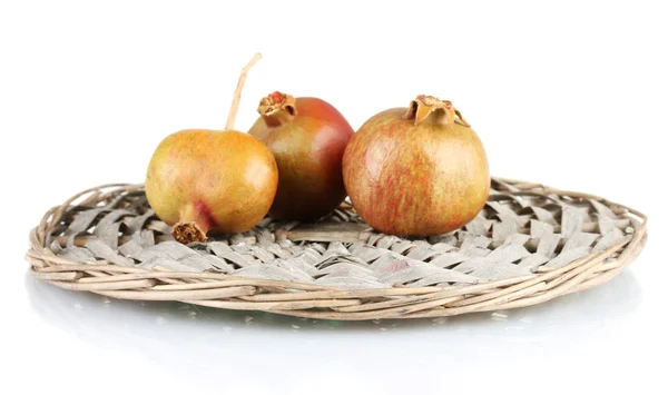 Unripe pomegranates on wicker mat isolated on white — Stock Photo, Image