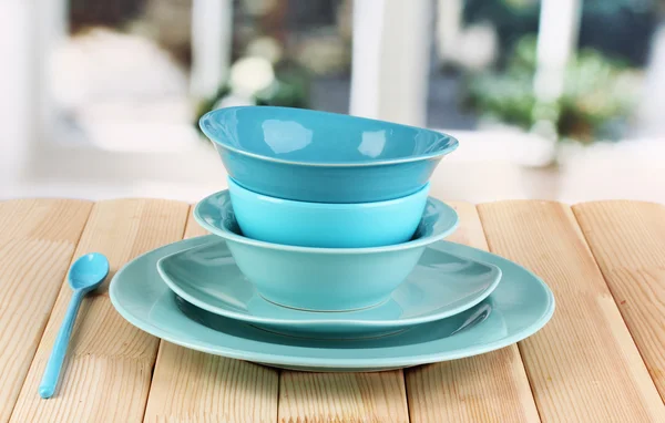 Blue tableware on wooden table on window background — Stock Photo, Image