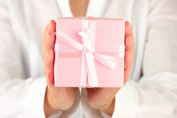 Woman holds a box with a gift on white background close-up — Stock Photo, Image