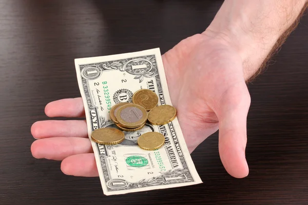 Contando dinheiro na mão em fundo de mesa de madeira — Fotografia de Stock