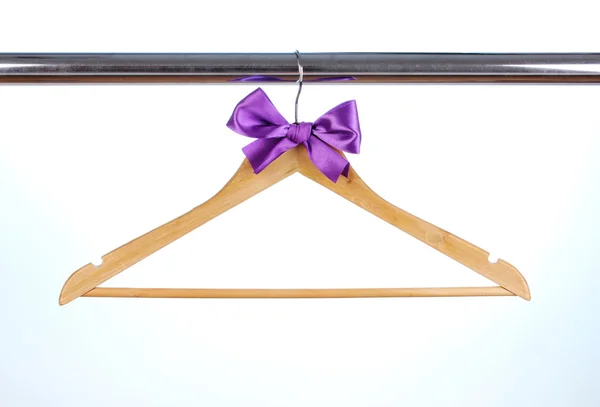 Beautiful purple bow hanging on wooden hanger on blue background — Stock Photo, Image