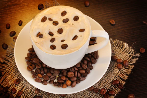 Latte na mesa de madeira no fundo marrom — Fotografia de Stock