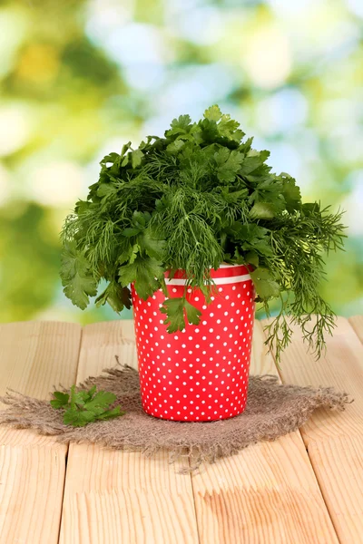 Roter Topf mit Petersilie und Dill auf Holztisch auf natürlichem Hintergrund — Stockfoto