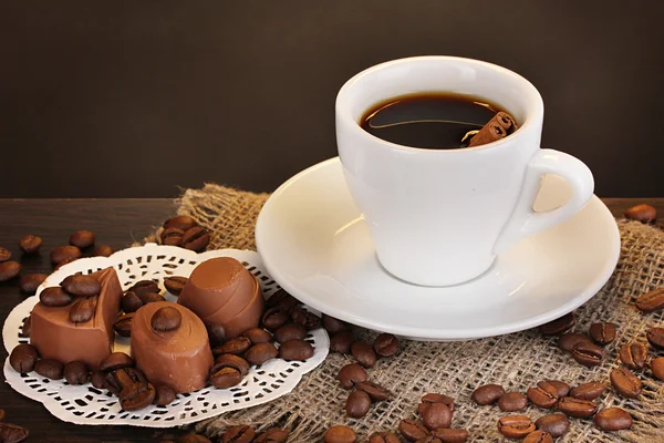 Filiżankę kawy na drewnianym stole na brązowym tle — Zdjęcie stockowe