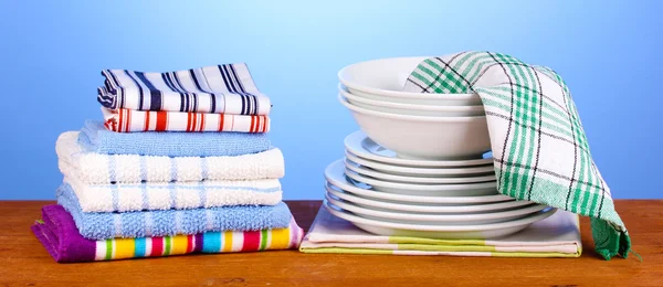 Toallas de cocina con platos sobre fondo azul primer plano — Foto de Stock