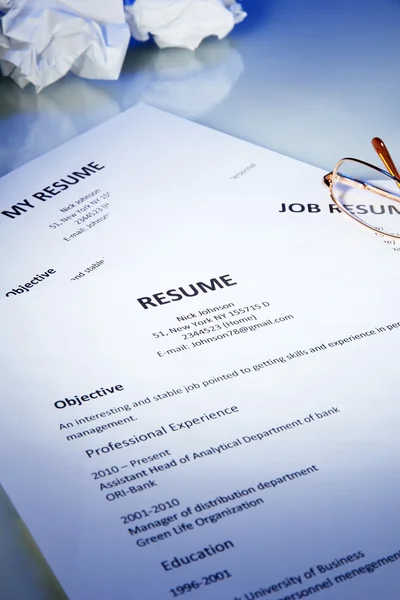 Closeup of resume with glasses on blue background — Stock Photo, Image