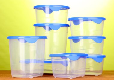 yeşil zemin üzerine ahşap masa yemek plastik kaplar