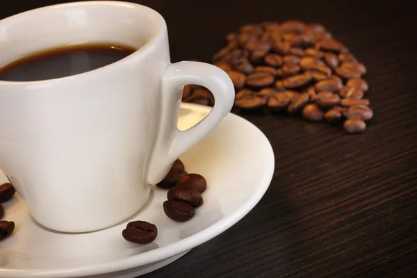 Cup of coffee on wooden table on brown background — Stock Photo, Image